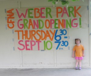 Penelope Christie standing with the sign she helped make!